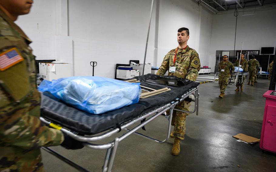 New Jersey National Guard Soldiers with Joint Task Force-57 (JTF-57) carry medical beds at the Meadowlands Exposition Center, Secaucus, N.J., on March 31, 2020. The JTF-57 is supporting state and local officials with the COVID-19 relief effort. 
