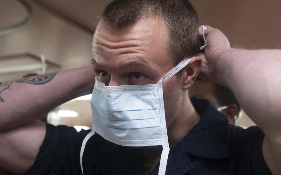 Seaman Thomas King dons a surgical mask during patient transport drills aboard hospital ship USNS Comfort in New York, March 31, 2020, as the ship prepares to admit patients in support of coronavirus response efforts. The Navy said that until official uniform ''face coverings'' can be produced, sailors can wear masks that comply with Center for Disease Control and Prevention guidelines.

