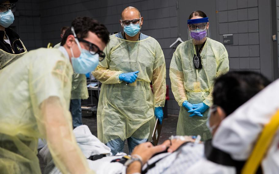 Soldiers assigned to Javits New York Medical Station conduct check-in procedures on an incoming COVID-19 patient in the facility's medical bay in New York City on Sunday, April 5, 2020.
