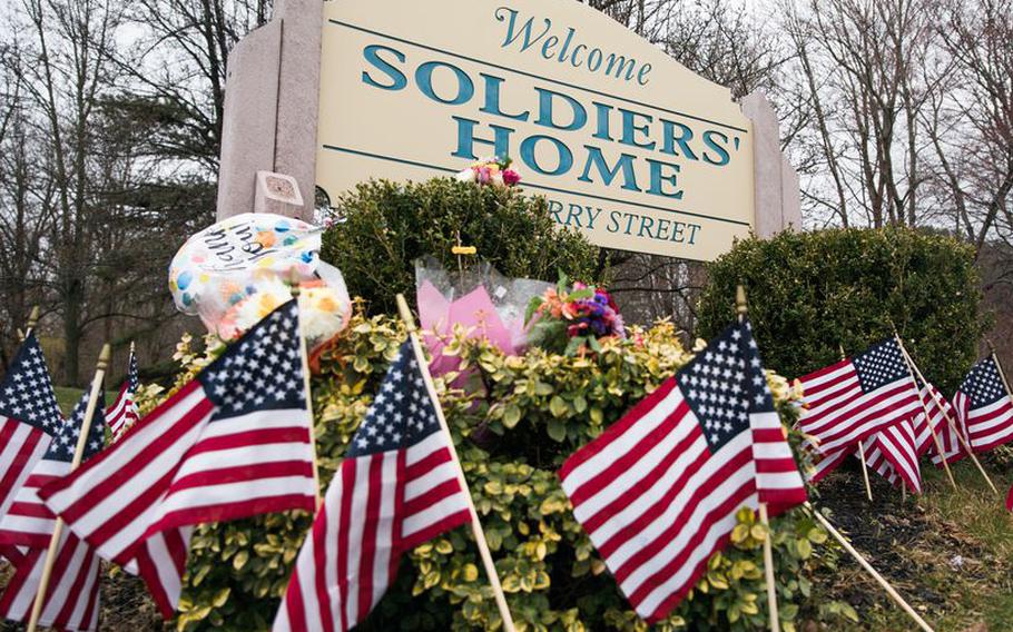 Flags and balloons are placed around the sign of Holyoke Soldiers' Home on April 3, 2020 in honor of the veterans who have died because of COVID-19.