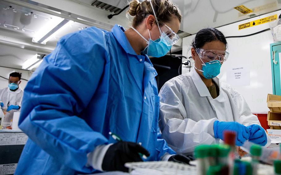 Navy Hospital Corpsman Jackii Cheung, right, and Army Spc. Cortney Elliot, both assigned to the Javits New York Medical Station, process blood samples from COVID-19 patients in the facility's medical laboratory, April 13, 2020.