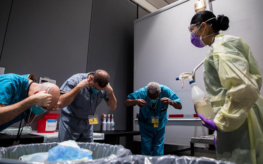 Navy Hospital Corpsman 3rd Class Katie Perez, assigned to Expeditionary Medical Facility Bethesda, Md., leads medical providers in removing their N95 masks in the personal protective equipment doffing station at Javits New York Medical Station, April 13, 2020.