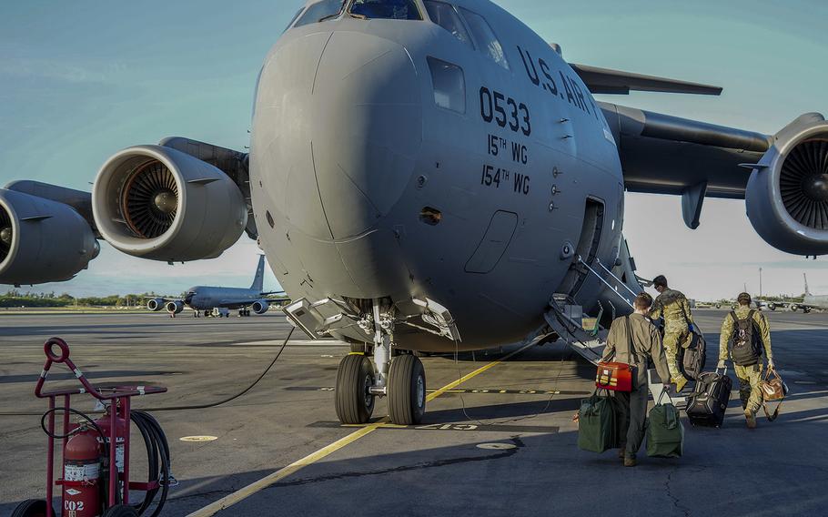 U.S. Air Force 535th Airlift Squadron pilots board a C-17 Globemaster III before taking off to Guam at Joint Base Pearl Harbor-Hickam, Hawaii, April 13, 2020. Defense Department officials announced on Saturday, April 17, that a new directive on the movement of military personnel and their families will bar travel through June 30.