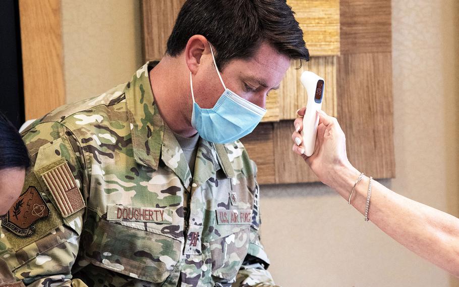 Cpt. Brendan Dougherty gets his temperature checked while filling out a medical screening questionnaire before entering the Broomall Rehabilitation and Nursing Center in Broomall, Pa., on April 18, 2020.