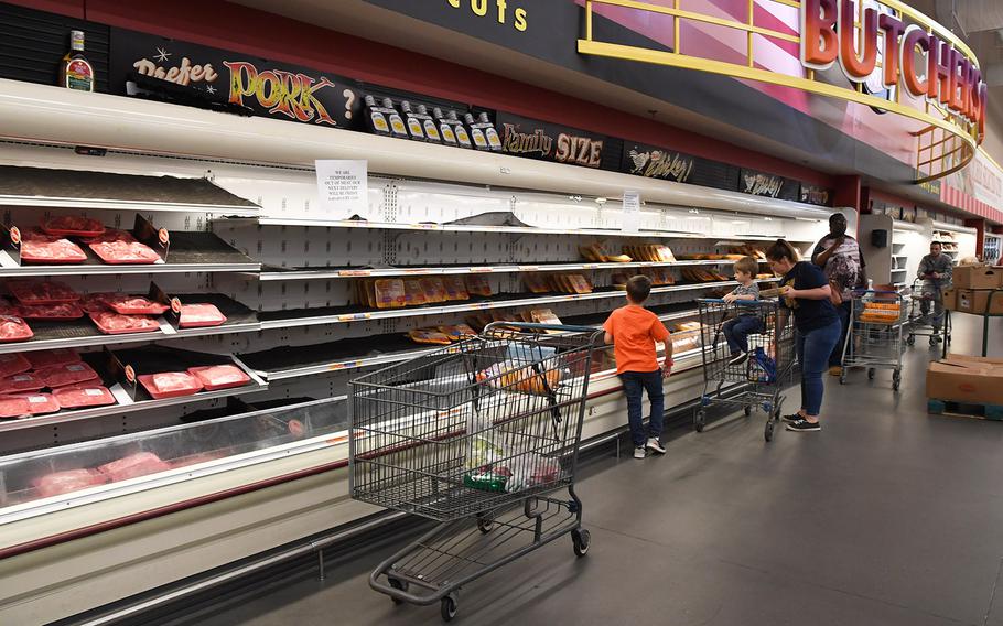 Keesler Air Force Base personnel select limited meat items for purchase inside the base commissary on March 20, 2020.