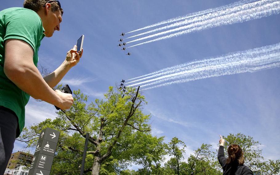People watch as the Blue Angels and Thunderbirds fly over Washington, in a "salute to frontline COVID-19 responders," as seen from the U.S. Marine Corps War Memorial, in Arlington, Va., Saturday, May 2, 2020