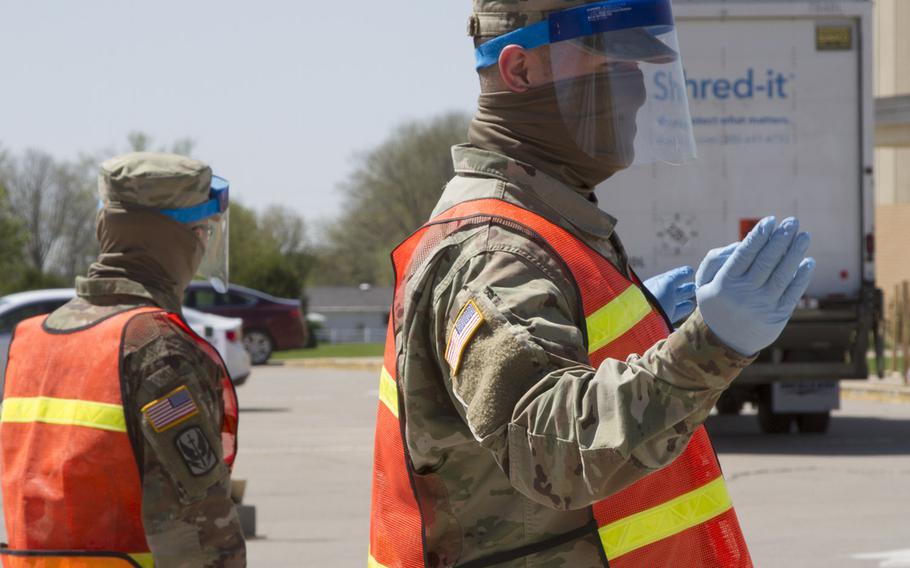 Spc. Colton Fenton and Spc. Kellen Korf, with Headquarters and Headquarters Company, 248th Aviation Support Battalion, Iowa Army National Guard, operate a traffic control checkpoint at a two-day, pop-up COVID-19 testing site at West Middle School in Muscatine, Iowa, on April 30, 2020.