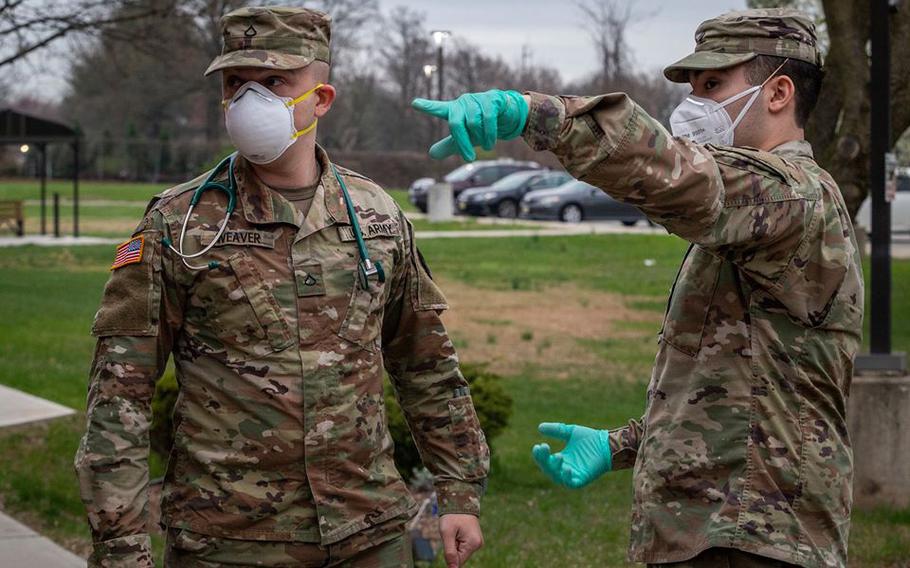 New Jersey Army National Guard Spc. Gabriel S. Fayed, right, directs Pfc. Jacob Weaver, both combat medics, toward the entrance of the New Jersey Veterans Home at Paramus, Paramus, N.J.