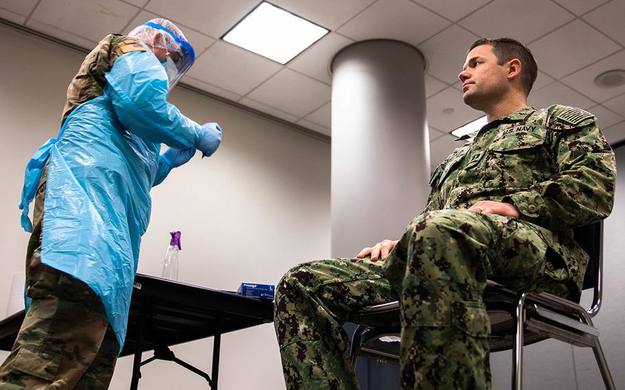 Army Pvt. Anthony Conway, assigned to the 531st Hospital Center, verifies a sailor's identity prior to testing for COVID-19 at the Javits New York Medical Station, May 6, 2020.