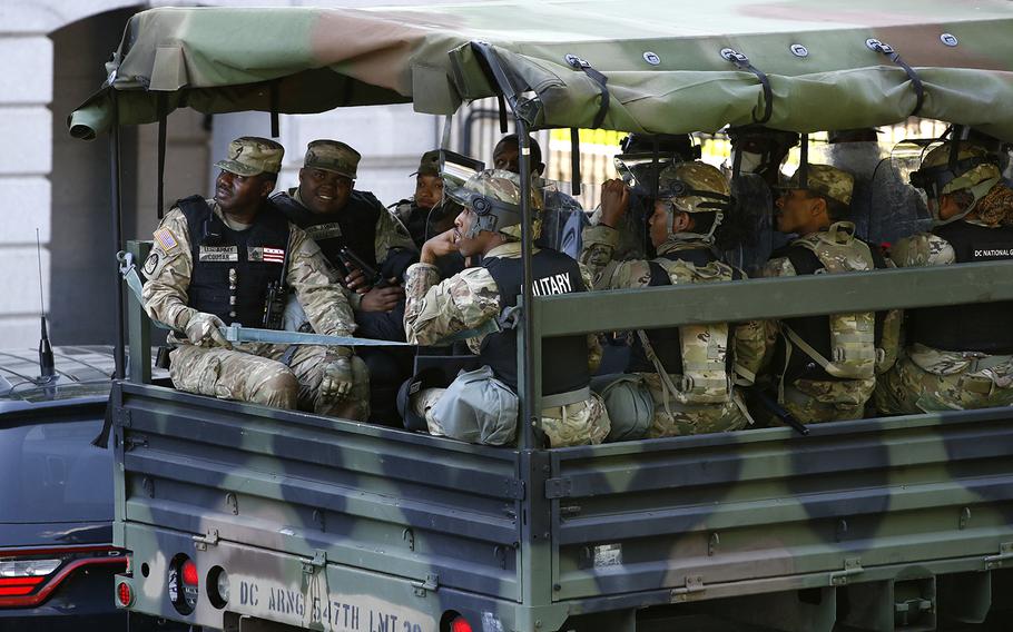 Members of the District of Columbia National Guard ride in a vehicle on West Executive Avenue next to the White House, Monday, June 1, 2020, in Washington.