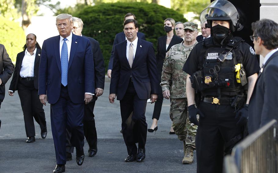 Defense Secretary Mark Esper, center, walks with President Donald Trump and Chairman of the Joint Chiefs of Staff Gen. Mark Milley as they depart the White House on Monday, June 1, 2020, to visit St. John's Church, which was set on fire during protests on Sunday night. 