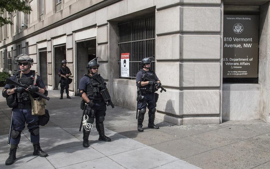 Police guard the Department of Veterans Affairs headquarters, damaged by vandals over the weekend, Wednesday morning, June 3, 2020, in Washington, D.C.