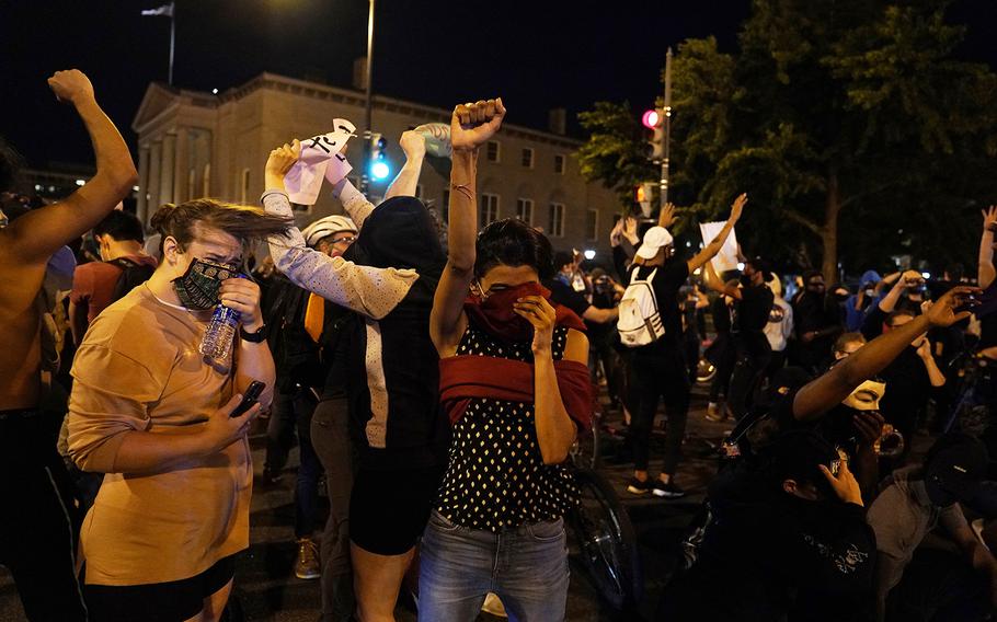 Demonstrators react as a helicopter circles low as people gather to protest the death of George Floyd, Monday, June 1, 2020, near the White House in Washington. Floyd died after being restrained by Minneapolis police officers.