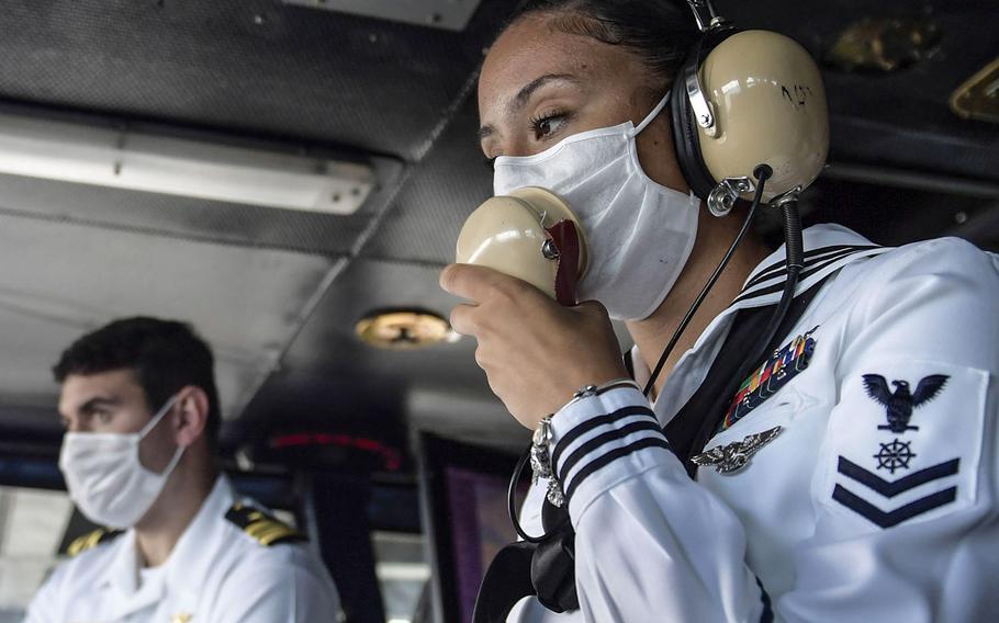 U.S. Navy Quartermaster 2nd Class Reyna Montueuses uses a sound powered phone in the navigation bridge of the aircraft carrier USS Theodore Roosevelt while departing Apra Harbor, Guam, June 4, 2020.