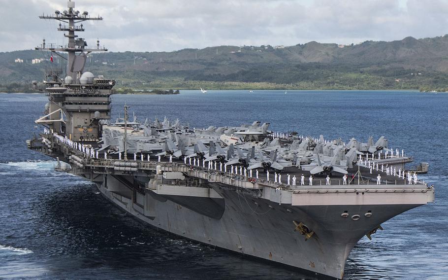 Sailors man the rails as the aircraft carrier USS Theodore Roosevelt departs Apra Harbor, Guam, June 4, 2020.