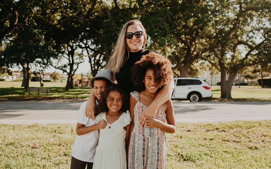 Kristin McKenzie and her kids (left to right) Grey, Lawton and Blake posed for photos as a white SUV pulled up in the background.