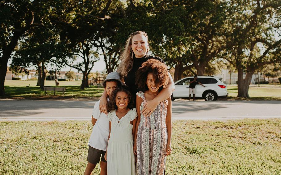 Kristin McKenzie and her kids (left to right) Grey, Lawton and Blake posed for photos as a white SUV pulled up in the background.