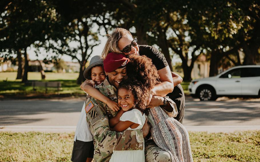 Lt. Col. Simon McKenzie reunites with his family after a deployment to Quatar.