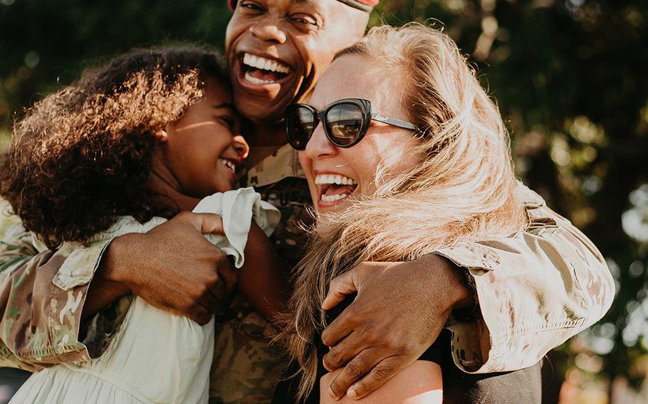 Lt. Col. Simon McKenzie smiles as he hugs daughter Lawton and wife Kristin after his 2020 deployment.