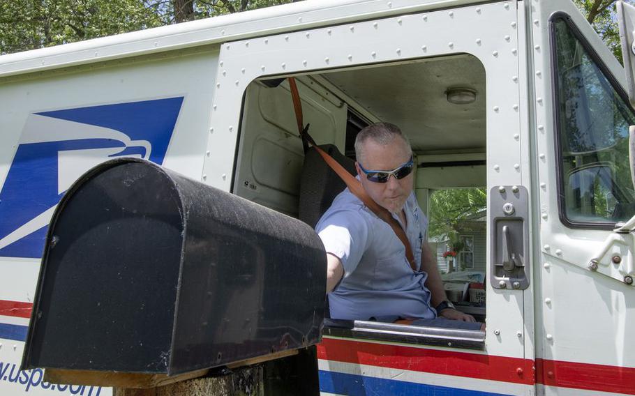 United States Postal Service carrier Joshua Davis delivers mail on his Jackson, Mich.-area route on Tuesday, June 9, 2020.