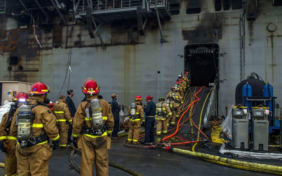 Sailors prepare to board the amphibious assault ship USS Bonhomme Richard at Naval Base San Diego, July 14, 2020, to support ongoing fire efforts.