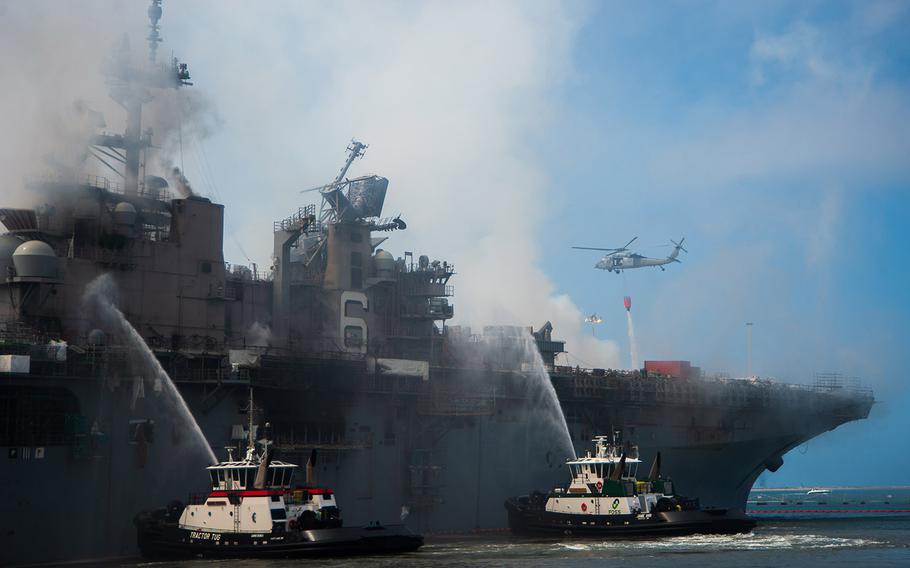 An MH-60S Seahawk helicopter, provides aerial firefighting support alongside sailors and civilian fire crews on the ground to fight the fire aboard amphibious assault ship USS Bonhomme Richard on July 13, 2020. On the morning of July 12, a fire was called away aboard the ship while it was moored pier side at Naval Base San Diego.
