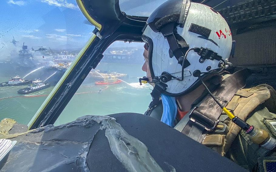 Lt. Matthew Wellens flies an MH-60S Seahawk helicopter to support aerial firefighting operations aboard the USS Bonhomme Richard on July 13, 2020. 