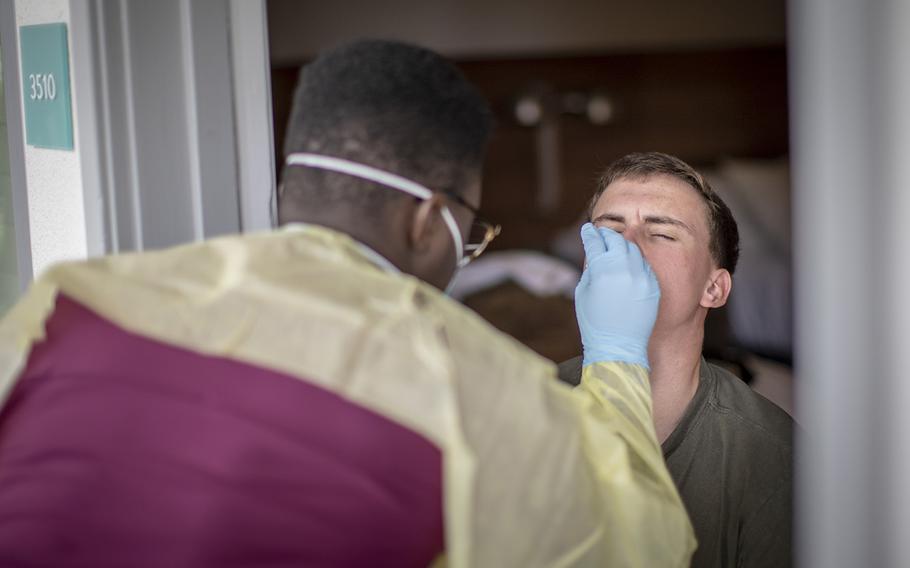 U.S. Navy Hospital Corpsman 3rd Class Brandon Smith, left, performs a COVID-19 swab test on a Marine ain San Diego on June 22, 2020.