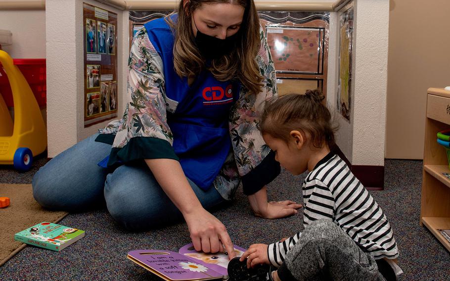 In a May 1, 2020 photo, Emilia Williams, 60th Force Support Squadron child and youth program technician, helps a child read a book at Child Development Center 3 at Travis Air Force Base, Calif.