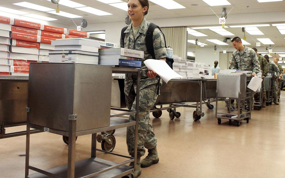 In a 2016 photo, first-year medical students at the F. Edward Hebert School of Medicine at the Uniformed Services University of the Health Sciences receive more than 140 pounds of books each inside the anatomy lab. A Politico report says the university is one of the DOD's targets for a considerable funding reduction.