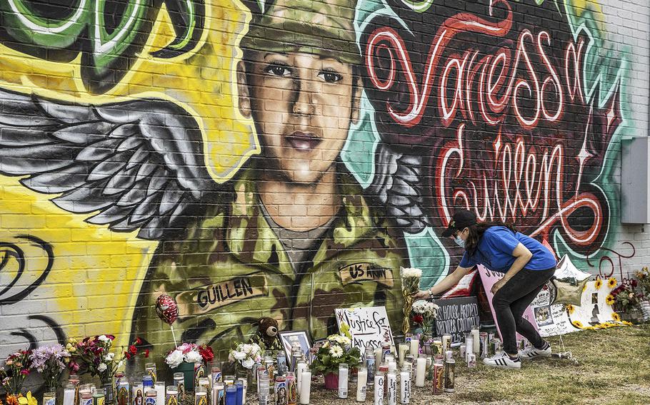 Mellisa Mendoza places white roses at a mural for Fort Hood Spc. Vanessa Guillen at a convenience store on July 6, 2020.