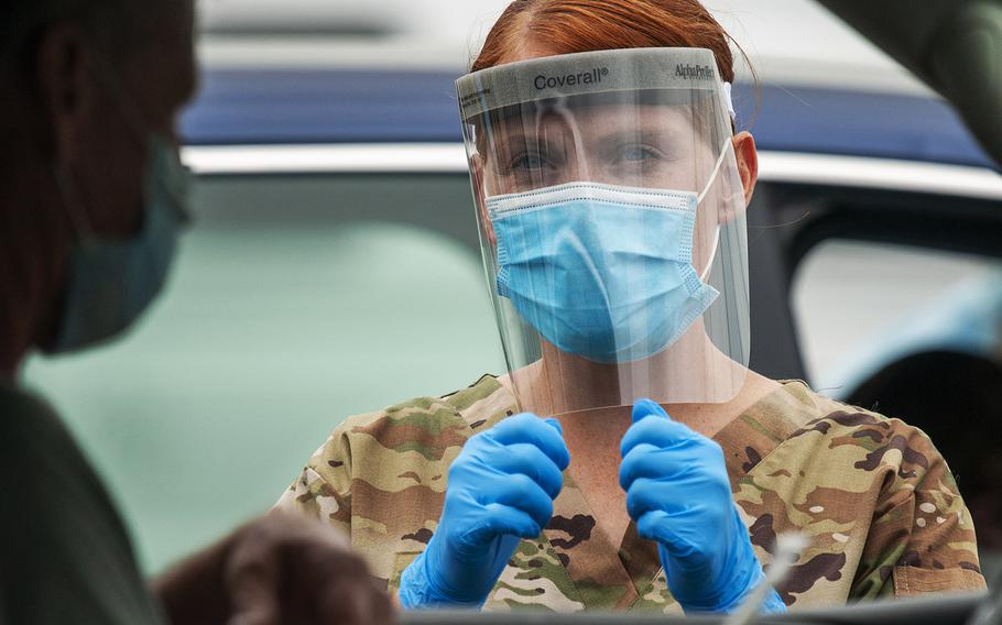 Pfc. Kelly Buterbaugh, a combat medic with the Delaware Army National Guard, gives instructions to a motorist during a drive-thru coronavirus testing mission at the University of Delaware's Science, Technology and Advanced Research Campus in Newark, Delaware, May 29, 2020.