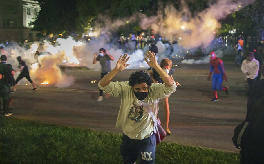 Tear gas lands around protesters after they refused to listen to police demands to disperse near the courthouse in Kenosha, Wisconsin on Tuesday, August 25, 2020.