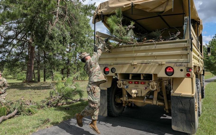 Cpl. Sebastian Tabarez, a preventative medicine specialist with C Co, 710th BSB, 3rd IBCT, 10th Mountain Division, loads debris into the back of a LMTV during hurricane recovery cleanup on Fort Polk.