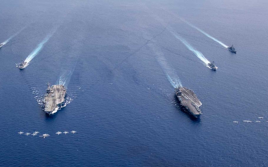  Aircraft from Carrier Air Wing 5 and Carrier Air Wing 17 fly in formation over the Nimitz Carrier Strike Force (CSF). The USS Nimitz (CVN 68) and USS Ronald Reagan (CVN 76) Carrier Strike Groups are conducting dual carrier operations in the Indo-Pacific as the Nimitz CSF.