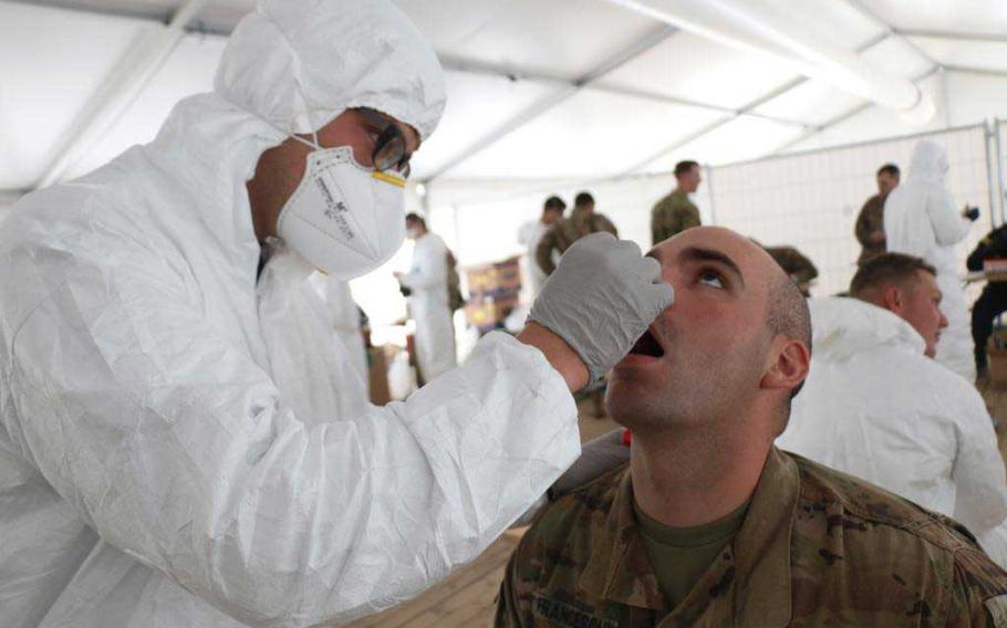 Spc. Matthew Murphy, a combat medic from the Headquarters and Headquarters Company, 3rd Battalion, 67th Armored Regiment, 2nd Armor Brigade Combat Team, 3rd Infantry Division tests Spc. Riccardo Franceschi from the 3rd Battalion, 15th Infantry, 2ABCT, 3ID for coronavirus in preparation for the Defender Europe 20 exercise at the Drawsko Pomorskie Training Area, Poland.