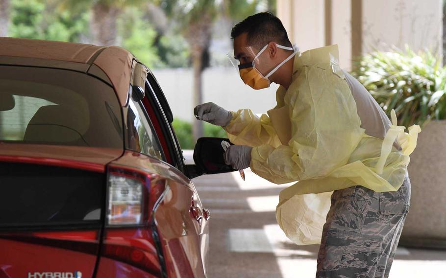 U.S. Air Force Staff Sgt. Mike Hansen, 81st Surgical Operations Squadron orthopedic technician, takes a patient's swab sample during a screening for COVID-19 symptoms outside the Keesler Medical Center at Keesler Air Force Base, Mississippi, March 23, 2020.