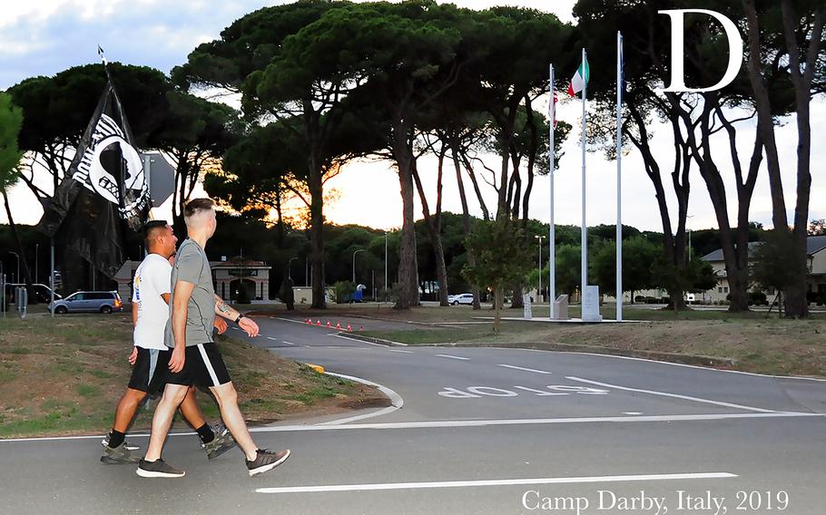 Two U.S Soldiers during the MIA/POW 24-hour Recognition Run held at Camp Darby, Italy, Sep 19, 2019. The Memorial run was held to remember the sacrifices and service of those who were prisoners of war (POW), as well as those who were missing in action (MIA), and their families. The flag displays a silhouette of a prisoner of war in front of a guard tower and the motto "You Are Not Forgotten" appears below the silhouette. The United States' National POW/MIA Recognition Day is observed across the nation on the third Friday of September each year. 