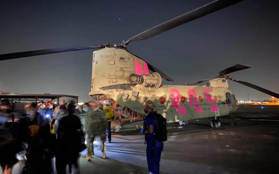 Evacuees from the Creek Fire in Fresno County, Calif., walk off a CH-47 Chinook from the 40th Combat Aviation Brigade of the California National Guard on Saturday evening. 