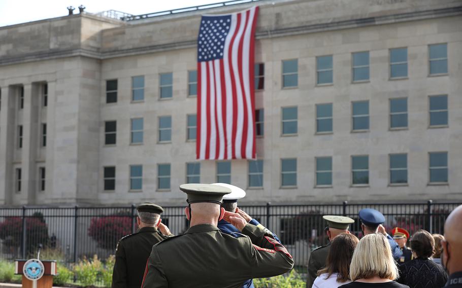 Attendees of the Pentagon's 9/11 observance ceremony stand and salute during "Taps" on Friday, Sept. 11, 2020. 