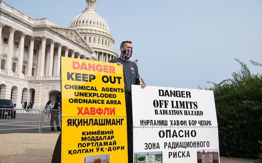 Retired Air Force Col. Paul Caltagirone holds signs in front of the U.S. Capitol in Washington on Tuesday, Sept. 15, 2020, as he joined other advocates lobbying for legislation that would provide benefits to military veterans who have been exposed to toxins from burn pits used at overseas locations. Caltagirone says he deployed three times to Karshi-Kanabad Air Base in Uzbekistan, while he was in the Air Force. He is now the financial director of the Stronghold Freedom Foundation.