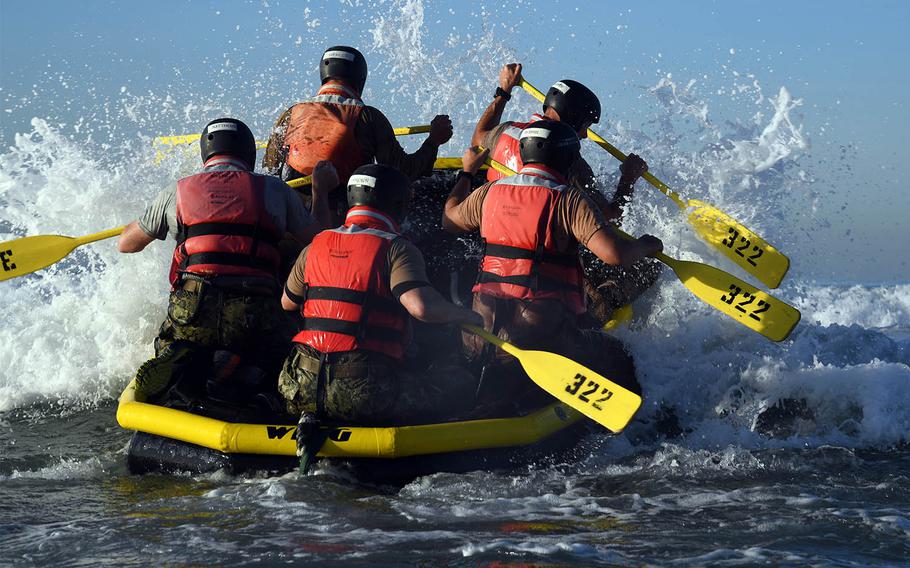 Senior officers and enlisted men paddle into the surf at Naval Amphibious Base Coronado during Surf Passage, a part of the first phase of SEAL training, Nov. 8, 2016.