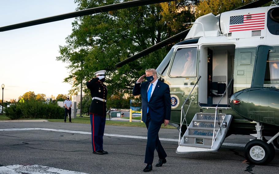 President Donald Trump salutes as he disembarks Marine One upon arrival to Walter Reed National Military Medical Center on Friday, Oct. 2, 2020, in Bethesda, Md