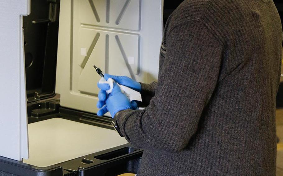 Master Sgt. Mike Moore, an airman with the 115th Fighter Wing, sanitizes voter pens after every use in Fitchburg, Wis., on April 7, 2020. More than 2,400 Citizen Soldiers and Airmen were mobilized to state active duty to assist as poll workers in the Wisconsin's primary election. Wisconsin National Guard photo by Spc. 