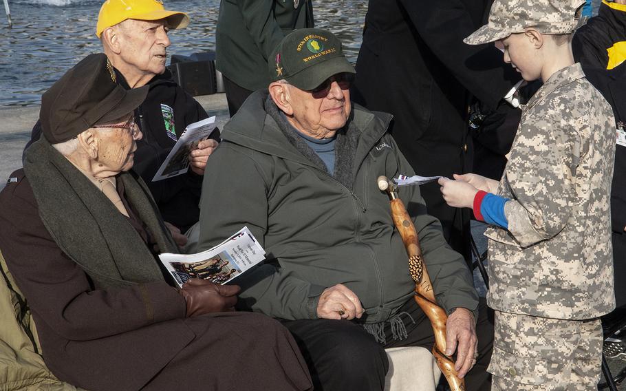 A young admirer talks to veterans at the National World War II Memorial in Washington, D.C., on Veterans Day 2019.