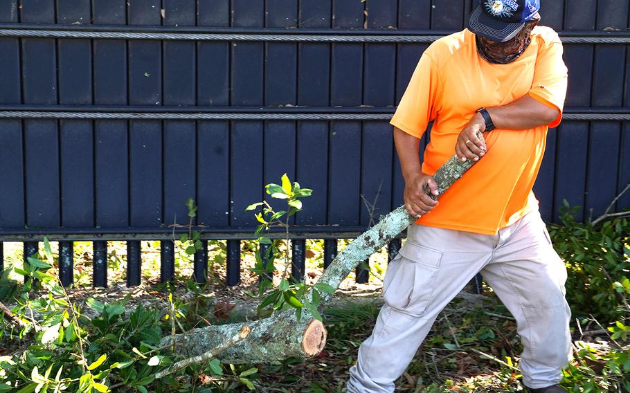 Adan Cardoza, a Vectrus ground landscaping maintainer, cleans up debris at Keesler Air Force Base, Miss., Oct. 29, 2020, in the wake of Hurricane Zeta.