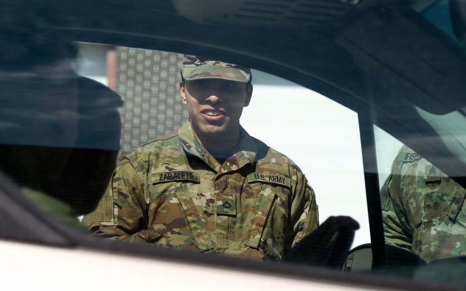 A Wisconsin National Guardsman directs a vehicle on March 21, 2020.