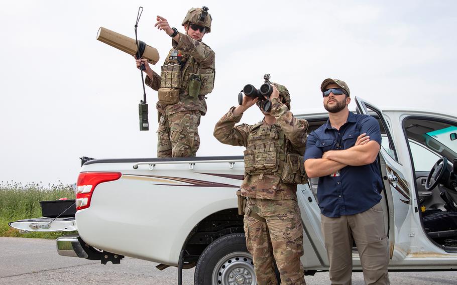 U.S. Army Sgt. Gage Stancell, right, looks through binoculars as Sgt. Gentry Squier describes where he saw a drone during an unmanned aerial system training exercise at Irbil Air Base in the Kurdistan Region of Iraq on April 24, 2020.