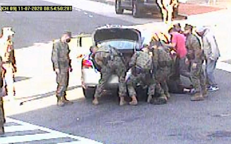 A video screenshot shows Marines in Washington, D.C., responding to an accident in which a woman was pinned underneath a car on Nov. 7, 2020. The Marines lifted the car using two jacks, saving vital time for fire and rescue officials who arrived on the scene shortly afterward.