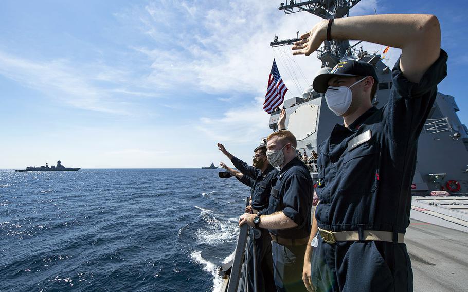 In a Nov. 20, 2020 photo, sailors on board the guided-missile destroyer USS Sterett wave to the crew of an Indian Navy vessel during Malabar 2020.